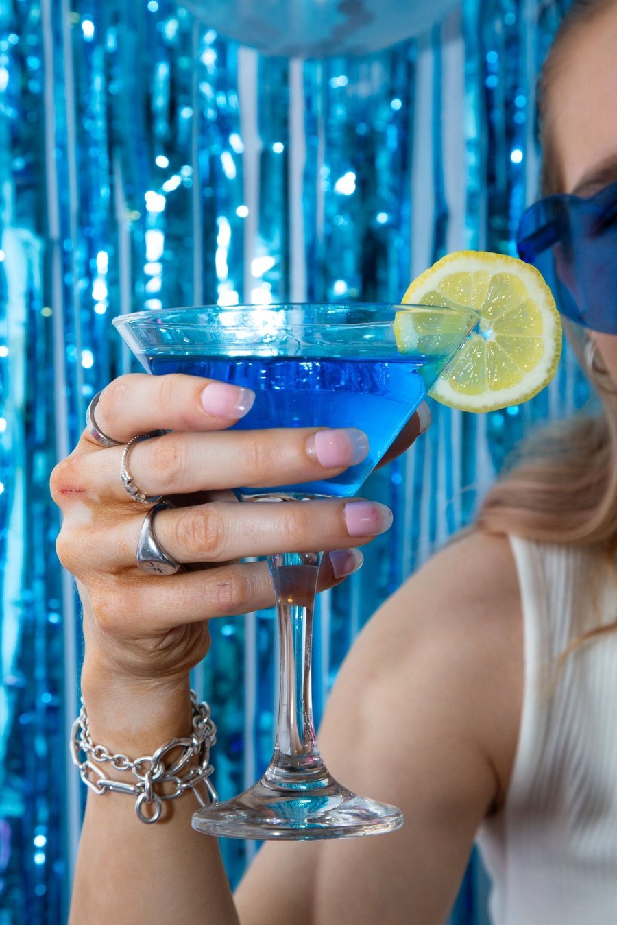 Guest holding a blue disco cocktail with lemon garnish