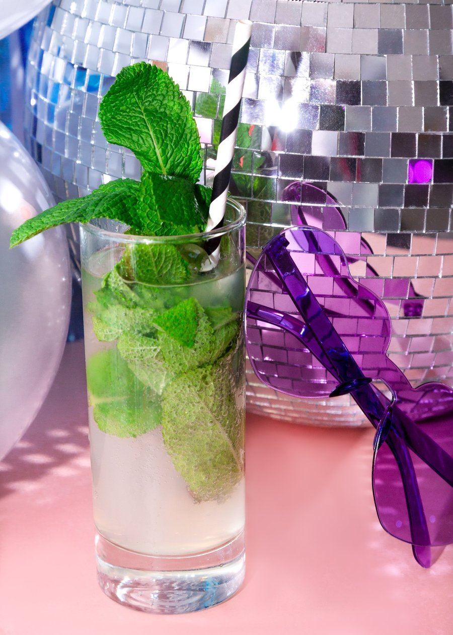 Mojito style disco cocktail with mint and striped straw